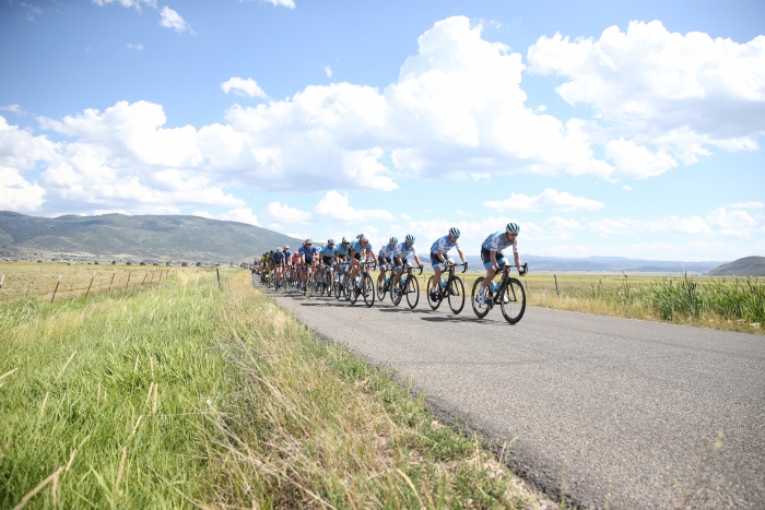 The peloton charges through beautiful farmland.