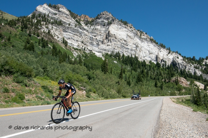 The Hellgate cliffs loom over Marko Pavlic (DC Bank Pro Cycling Team) as he rips the descent during the Prologue at Snowbird, 2019 LHM Tour of Utah (Photo by Dave Richards, daverphoto.com)