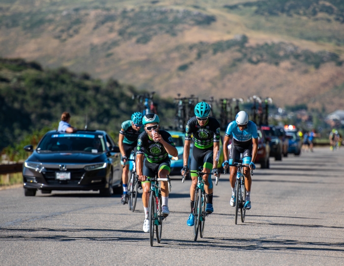 A Worthy Pro Cycling rider enjoying a tasty beverage over the top of Olympic Park. Stage 5, 2019 Tour of Utah. Photo by Steven L. Sheffield