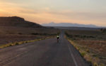 Doug Fujii riding at sunrise in southeastern Utah on one of many long stretches of road with spectacular views in the 2021 Race Across the West – photo by Vin Wolff